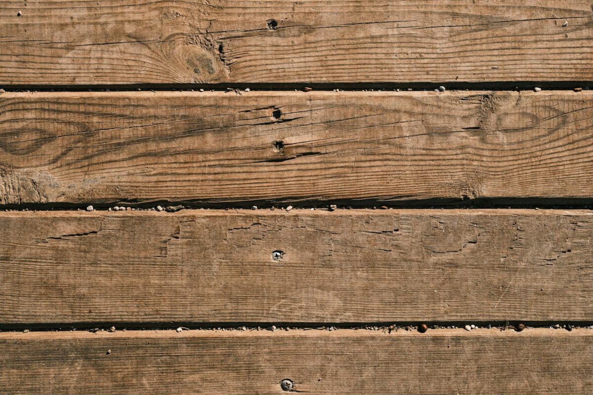 Close-up of natural wooden planks showcasing unique grain and texture, perfect as a background.