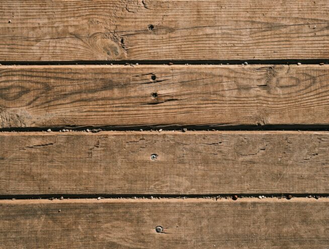 Close-up of natural wooden planks showcasing unique grain and texture, perfect as a background.